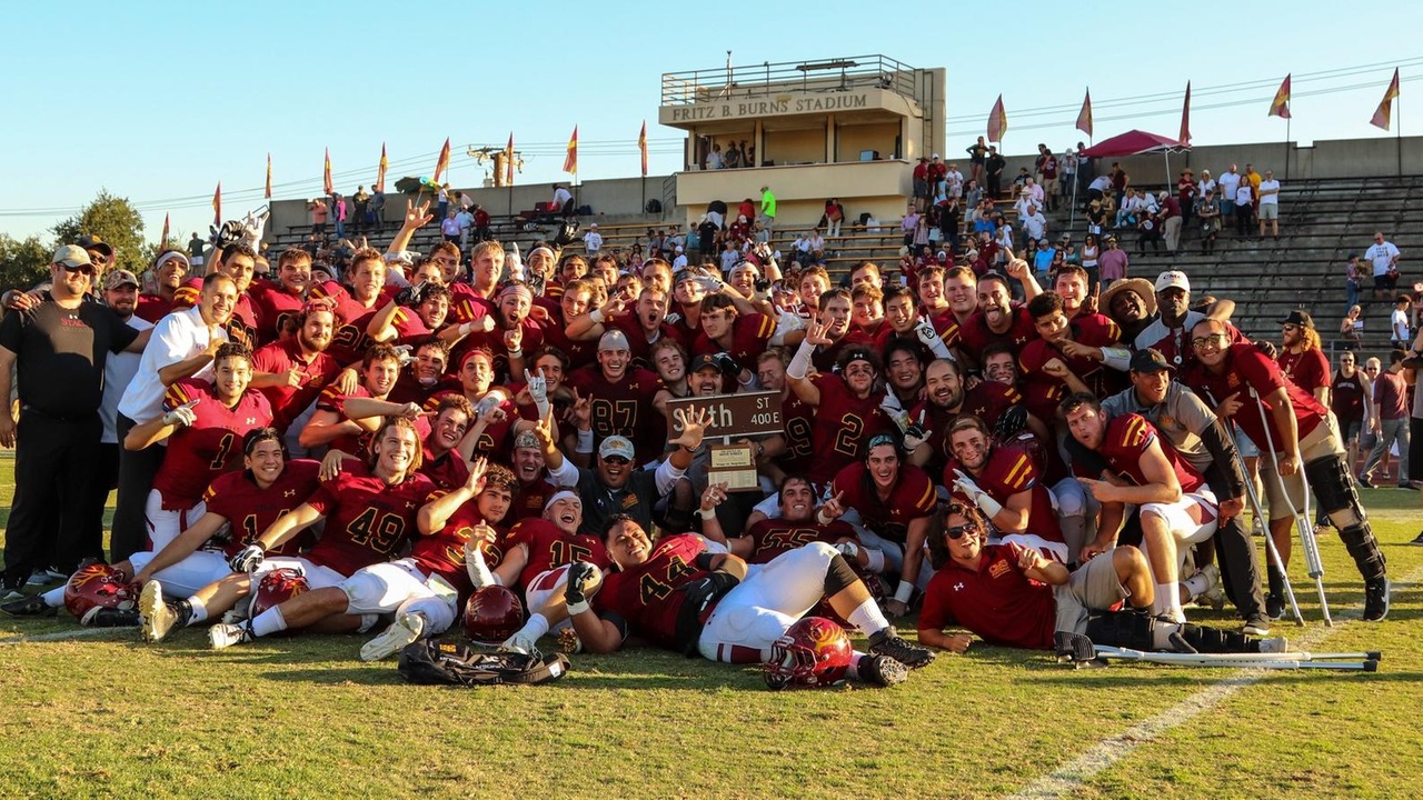 The Stags celebrate with the Sixth Street Trophy after a 20-17 win (photo by Daniel Addison)