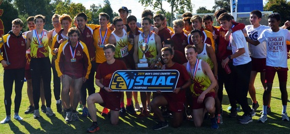 Team celebrating with 2019 SCIAC Championship banner