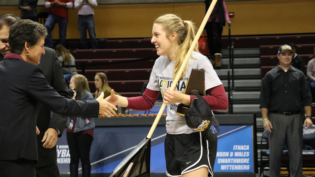Jenny Smith receives her NCAA Championship medal, while holding the rake that became a symbolic part of the team's success